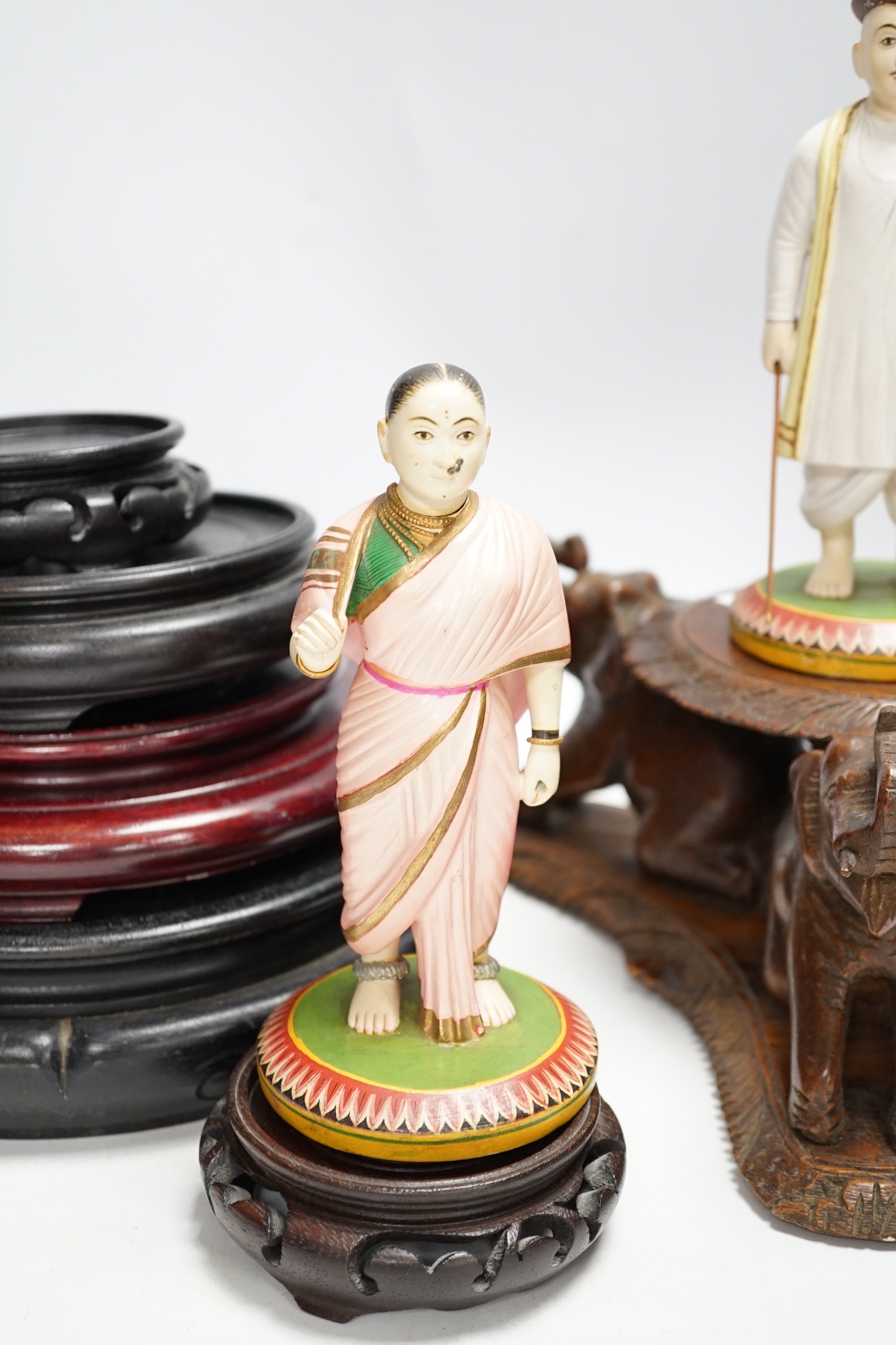 Two Indian carved and painted wood figures, an Indian or Burmese carved wood stand another various wood stands, largest 24cm in diameter